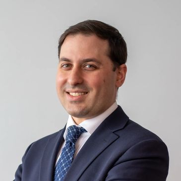 Professional man in a suit smiling confidently.