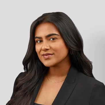 Professional woman with long dark hair wearing a black blazer.