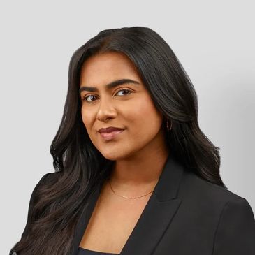 Professional woman with long dark hair wearing a black blazer.