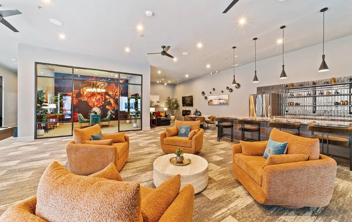 Modern lounge area with cozy orange chairs and bar seating.