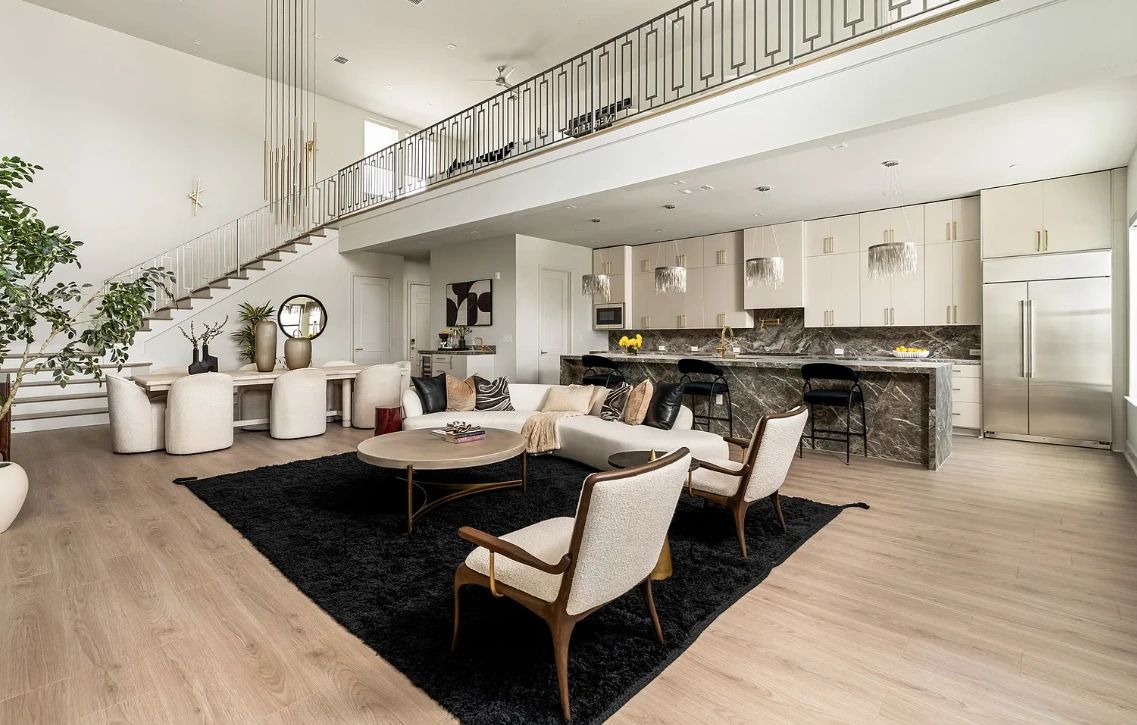 Spacious modern living room and kitchen with high ceilings and stylish furniture.