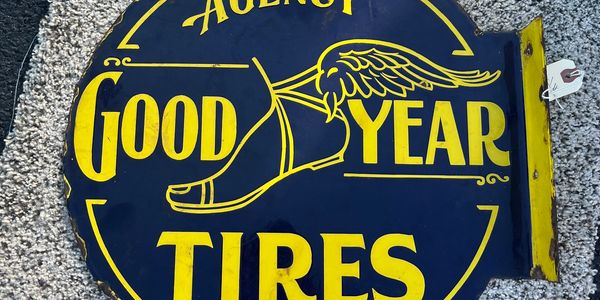 Vintage Goodyear Tires sign with winged foot logo.
