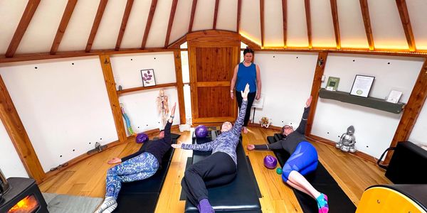 Group yoga session indoors with instructor guiding.