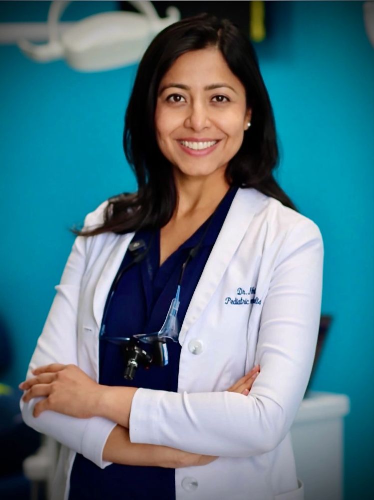 Confident female pediatrician smiling with arms crossed.