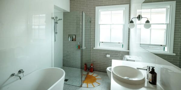 Well-maintained residential bathroom featuring vanity, mirror, toilet, and shower area.