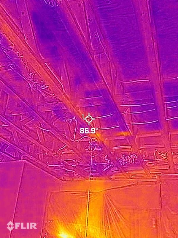 Thermal image of a ceiling with exposed beams showing heat distribution.