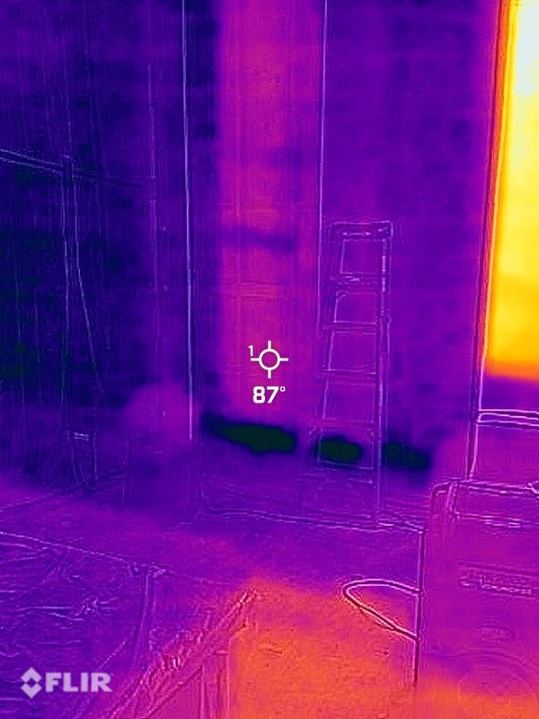 Thermal image showing temperature variations in an indoor room with a ladder and furniture.
