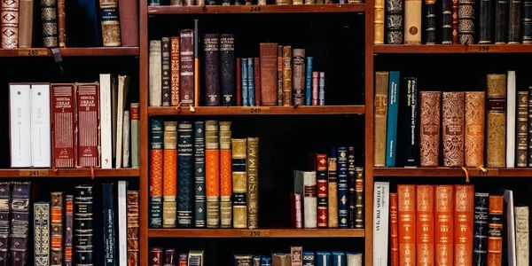 A bookshelf filled with a variety of vintage and classic books.