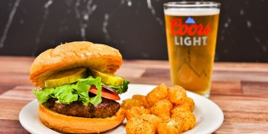 Handcrafted pub burger served with fries and a Coors Light