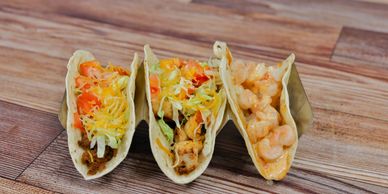 Three tacos, beef taco, chicken taco, and shrimp taco