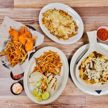 Assortment of pub favorites including wraps, fries, shrimp, and appetizers