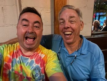 Two men laughing together in a bar