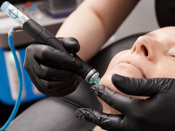 Professional facial skin treatment with a handheld device.