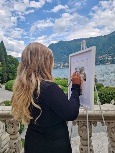 Live wedding painting of couple holding hands at Villa Erba, Lake Como, Italy. 