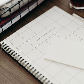 Empty spiral planner on wooden desk.