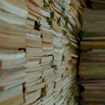 Large stacks of old books piled closely together.