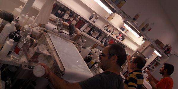 Trois hommes travaillent dans un atelier d'art.