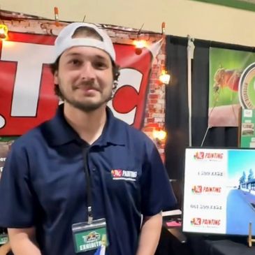 Man in a navy blue shirt and white cap at an event booth.
