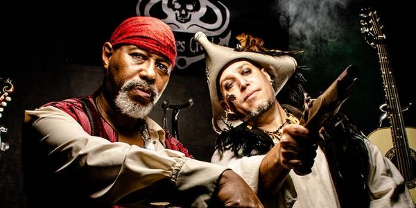 Two men dressed as pirates posing with a sword.