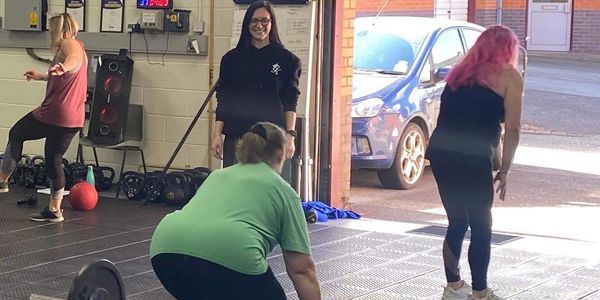 Brydie watching as a Strong Woman deadlifts