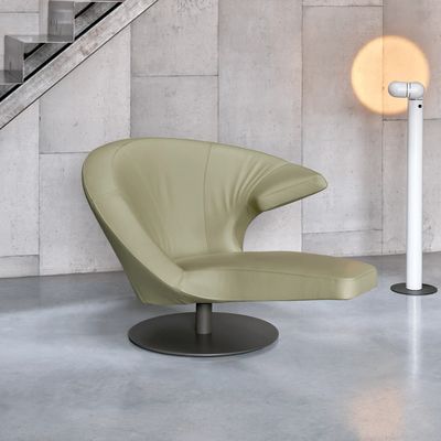 Moderne groene stoel in minimalistische ruimte.