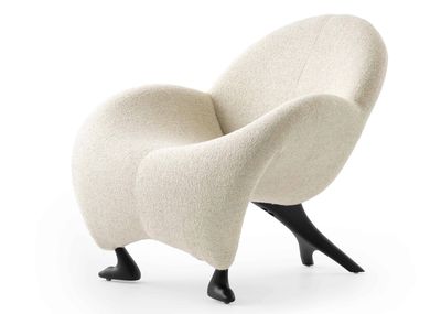Unique armchair with sculptural black legs and soft white upholstery.