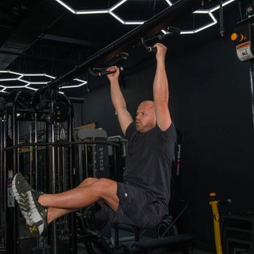 Man doing pull-up exercise in gym.