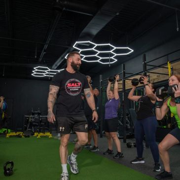 Fitness trainer supervising group exercise with kettlebells.