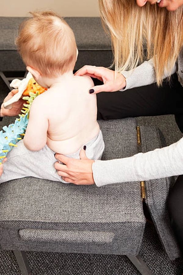 Chiropractor assessing a childs spine