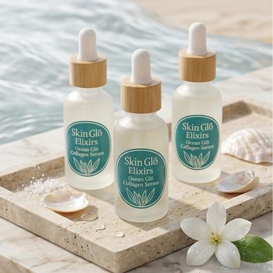 Three bottles of Skin Glō Elixirs Ocean Glō Collagen Serum on a stone tray by water.