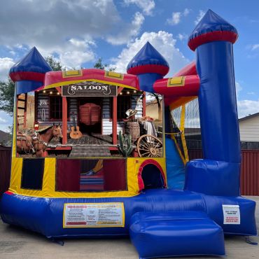 Inflatable bounce house with a Wild West saloon theme under a partly cloudy sky.
