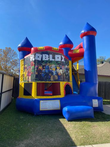 Colorful Roblox-themed bounce house set up in a backyard on a sunny day.