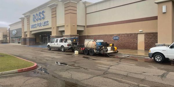 Exterior of Ross Dress for Less with trucks and equipment outside on a wet parking lot.