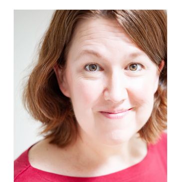 Smiling woman with light brown hair and pink top.