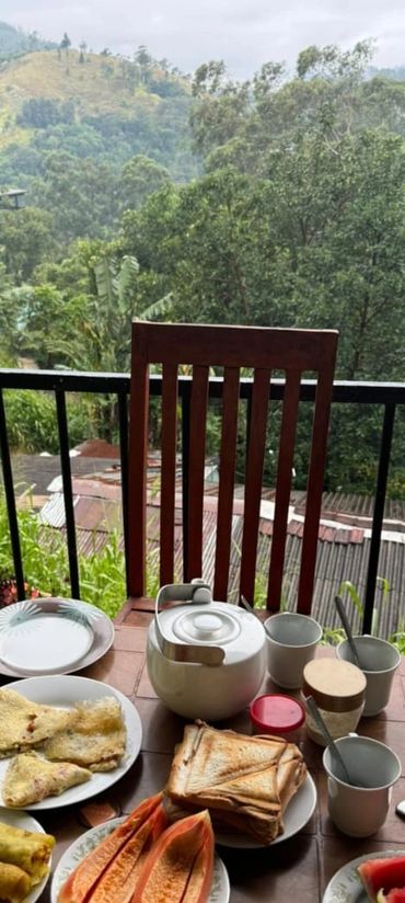 Breakfast spread on a table with a scenic mountain view in the background.
