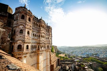 Historic fort with intricate architecture overlooking a cityscape under a bright sky.