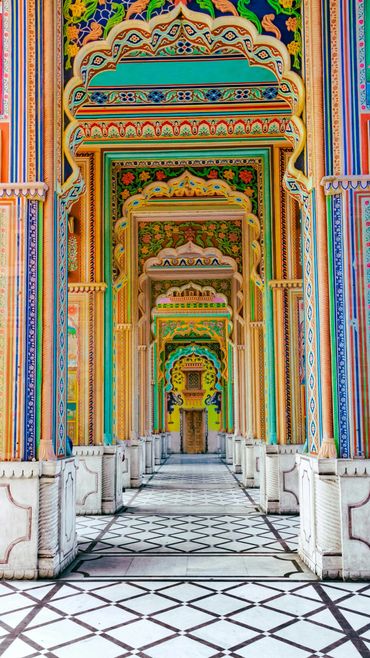 Colorful intricately painted arches in a traditional Indian palace corridor.