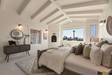 Cozy bedroom with a view of Seattle's Space Needle and modern decor.