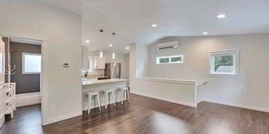 Bright, open living space with kitchen and hardwood floors.