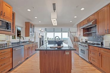 Spacious modern kitchen with wooden cabinets and a large island.