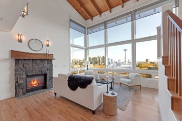 Modern living room with a fireplace and panoramic city view.
