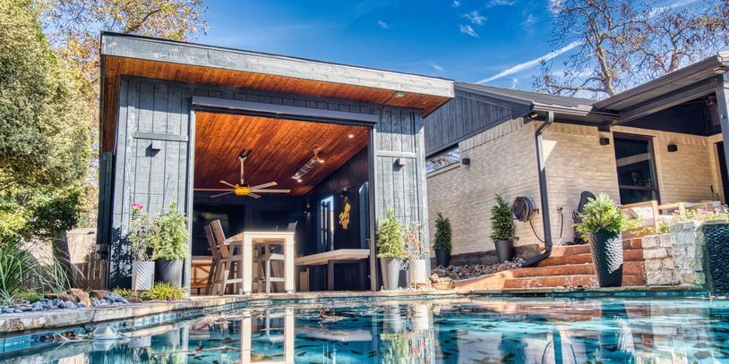 Modern backyard pool area with a cozy wooden pavilion and outdoor seating.