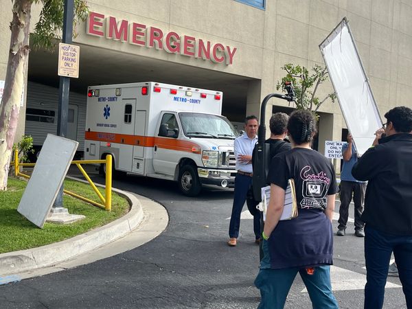 Ambulance arriving at emergency entrance with crew and equipment.