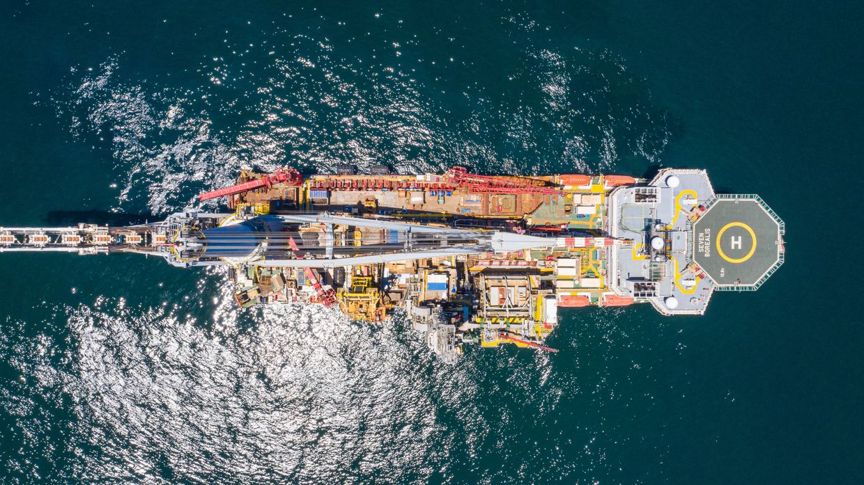 Aerial view of an offshore oil rig in the ocean with a helipad.