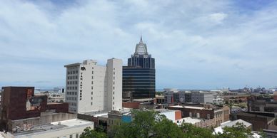 City skyline with a mix of modern and older buildings under a blue sky.