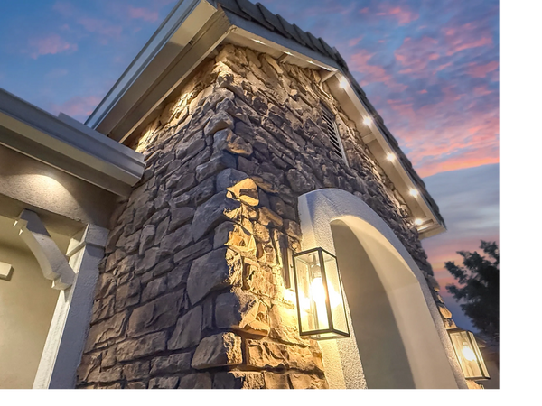 Stone exterior wall with warm lighting at dusk.