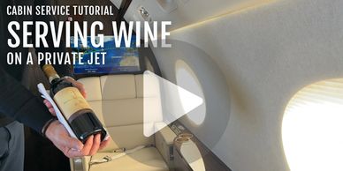 A flight attendant serving wine inside a luxurious private jet.