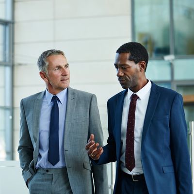 Male CEO collaborating with virtual COO while walking through office lobby