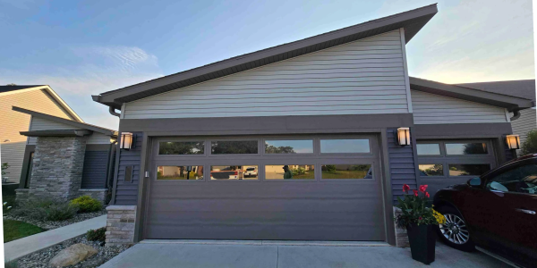Modern garage door with windows and exterior lights.