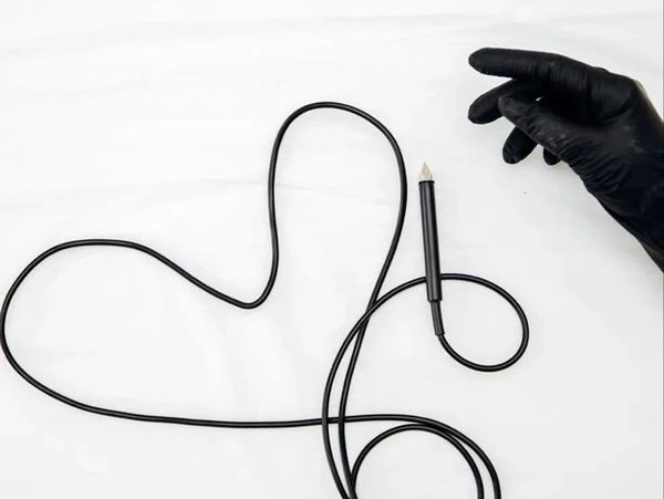 Black cable shaped like a heart with a gloved hand nearby.